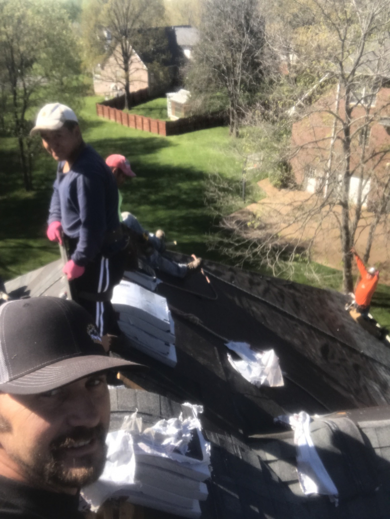 Two Brentwood, TN roofers smiling, working on a new shingle roof installation