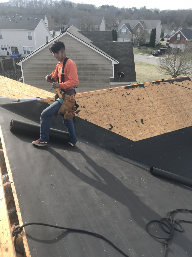 Franklin roofer from Five Points Roofing Company standing on top of a roof working on a shingle roof installation