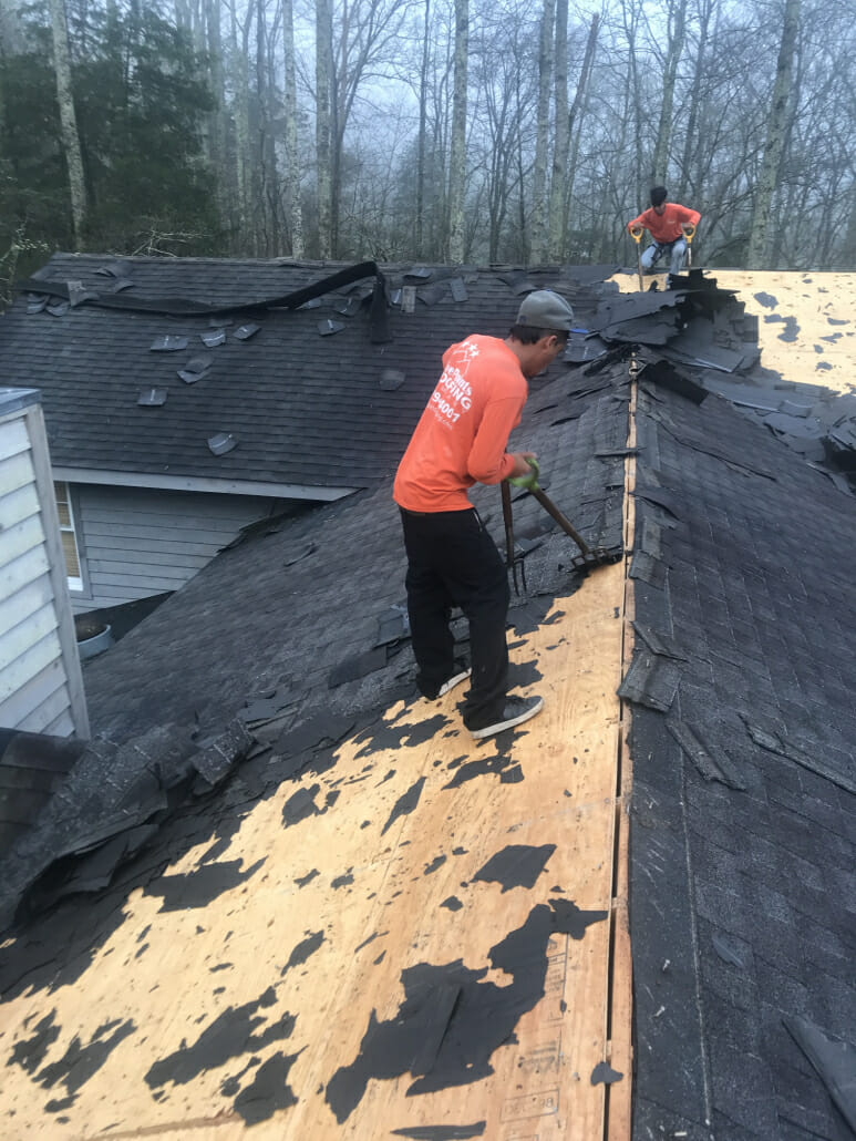 Two Murfreesboro roofers removing a black shingle roof for a roof replacement