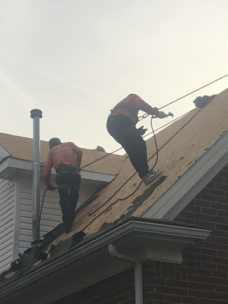 Two Thompson's Station roofers completing a roof replacement