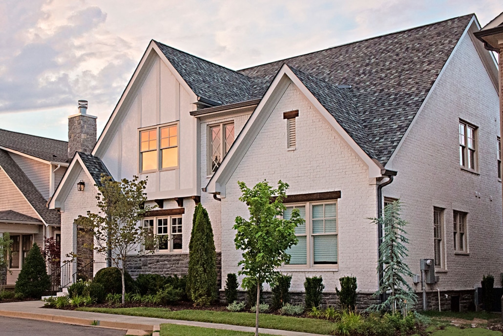 White brick Middle Tennessee home with shingle roof during sunset