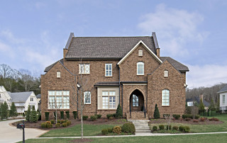 Large, brick home in Middle Tennessee with grey shingle roof
