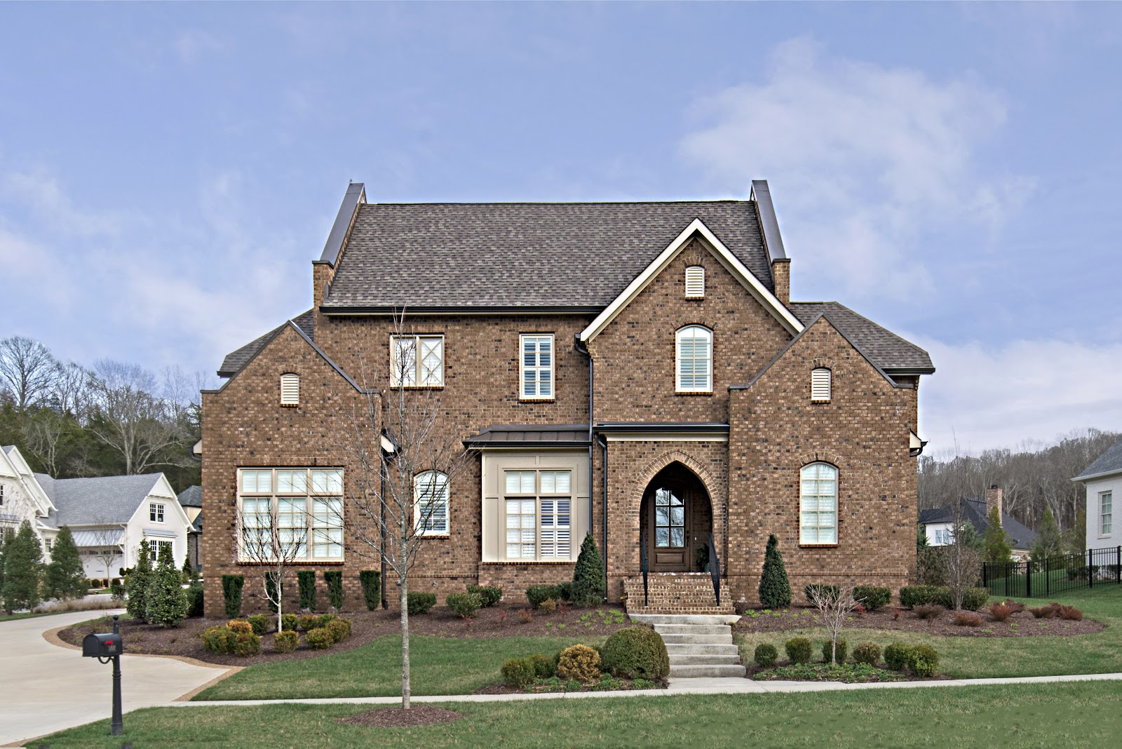 Large, brick home in Middle Tennessee with grey shingle roof