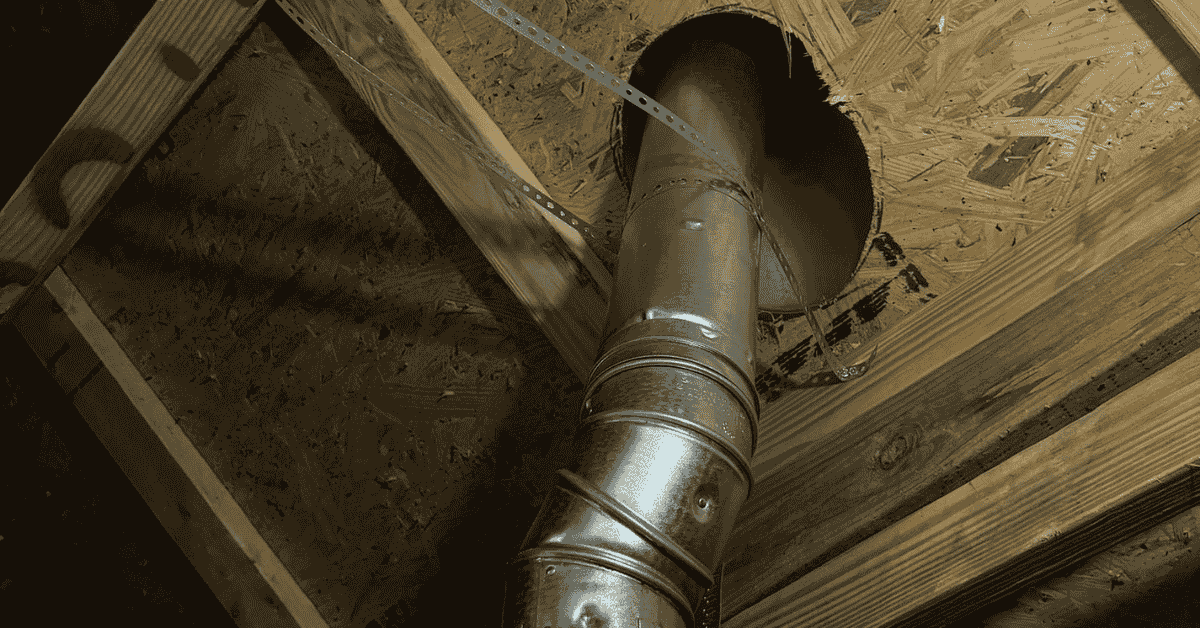 View of metal ductwork installed in an attic, secured with brackets.