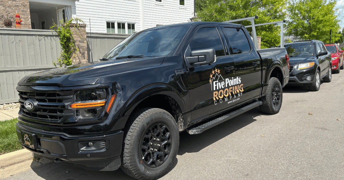 Close-up of Five Points Roofing Company logo on a black truck.