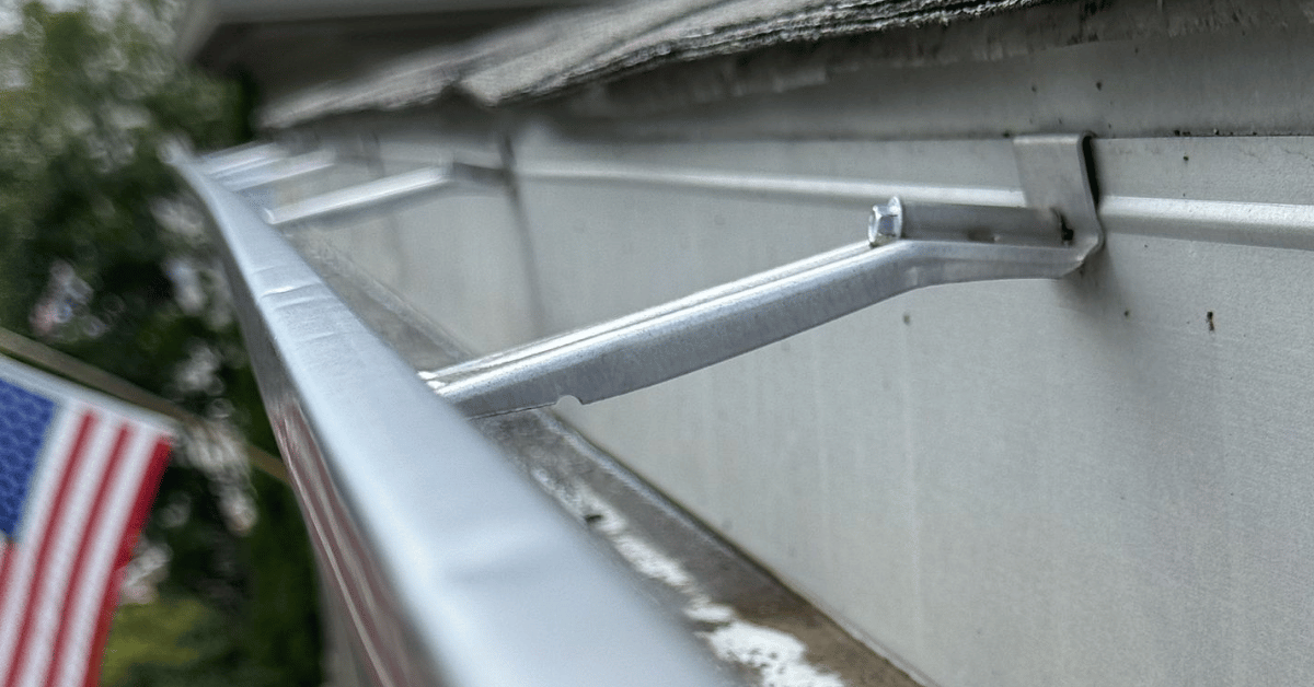 A close-up view of a gutter hanger system supporting the gutter along a home’s roofline.