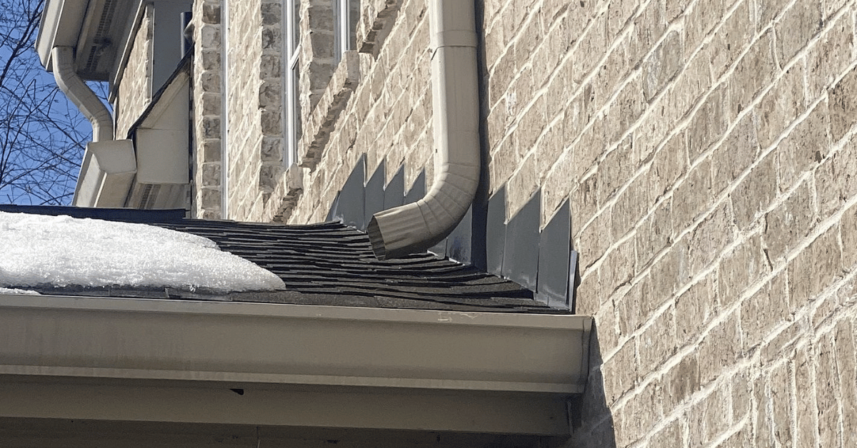 Snow and ice buildup along a roof gutter causing strain.