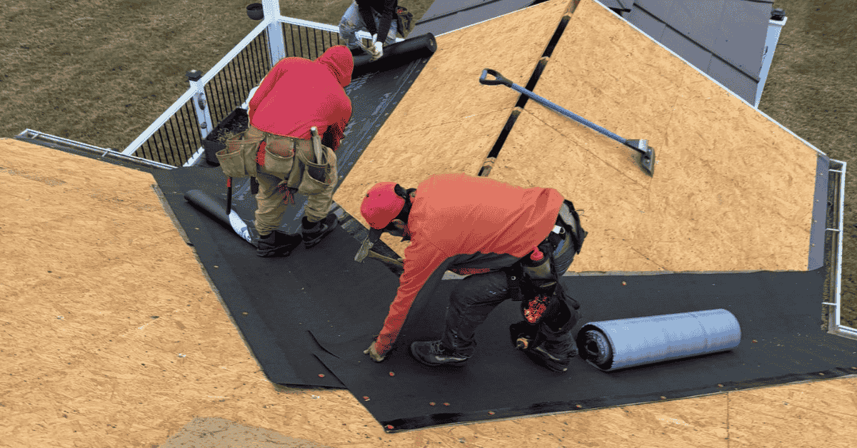 Roofing professionals installing a new roof underlayment.