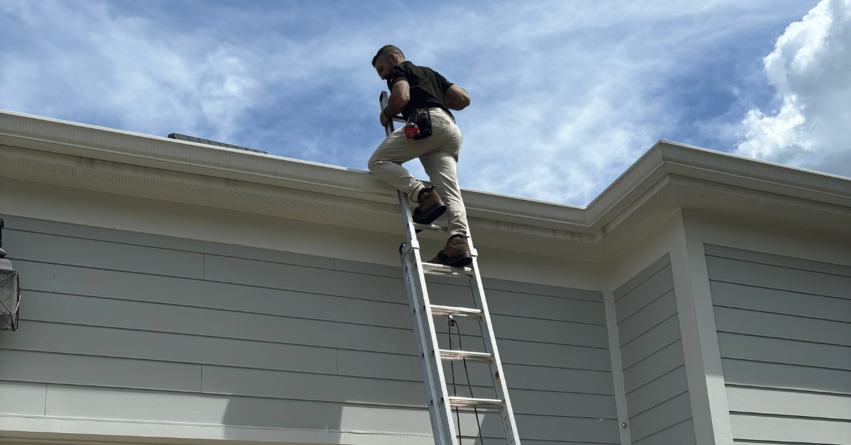 A roofer climbing a ladder towards a roof, emphasizing safety and professionalism.