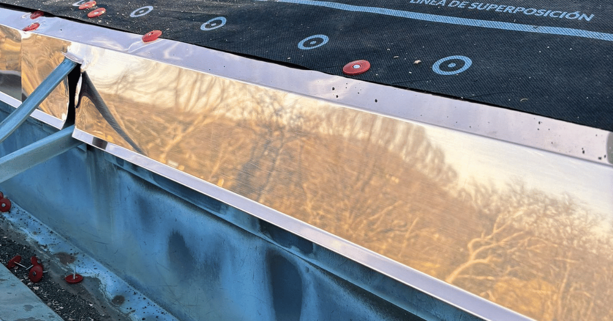A newly installed reflective sheet metal flashing system on a flat roof.
