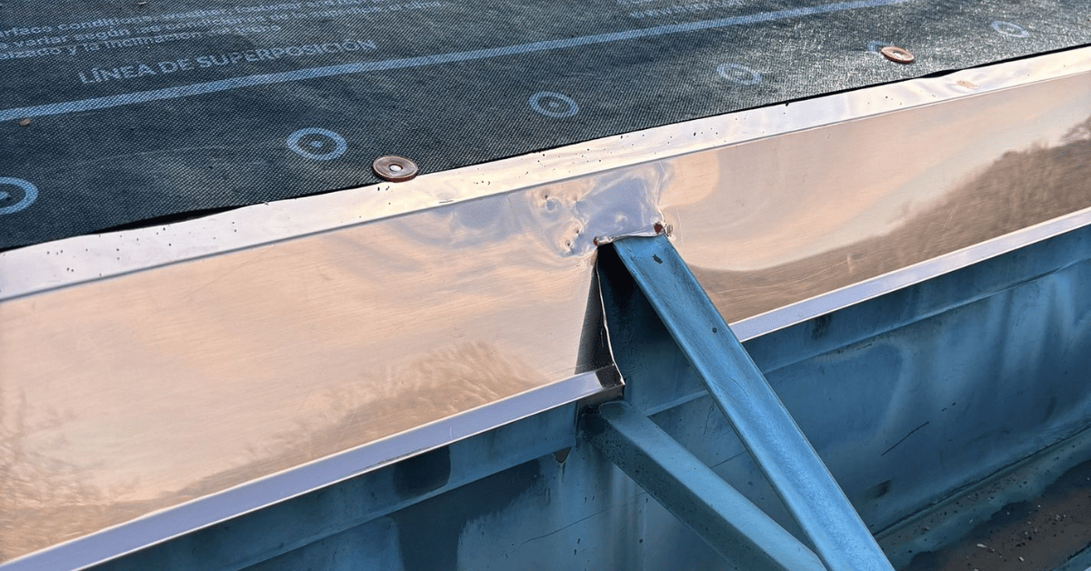 A commercial building with newly installed metal flashing along the roof perimeter.