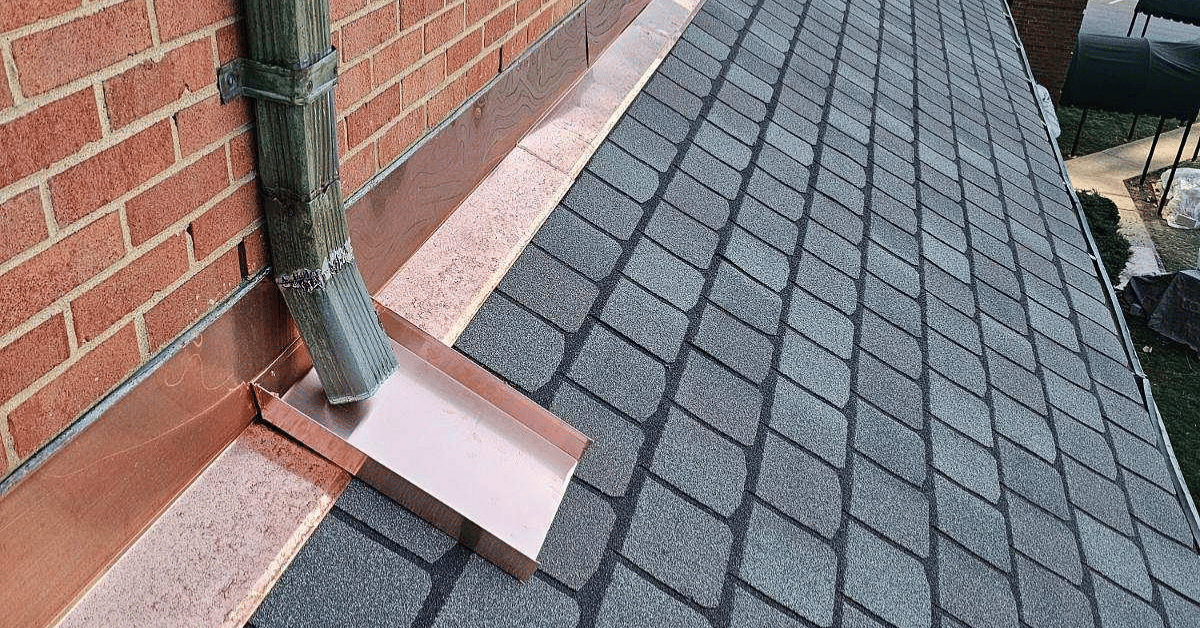 A close-up of a copper roof flashing system directing water away from the structure.