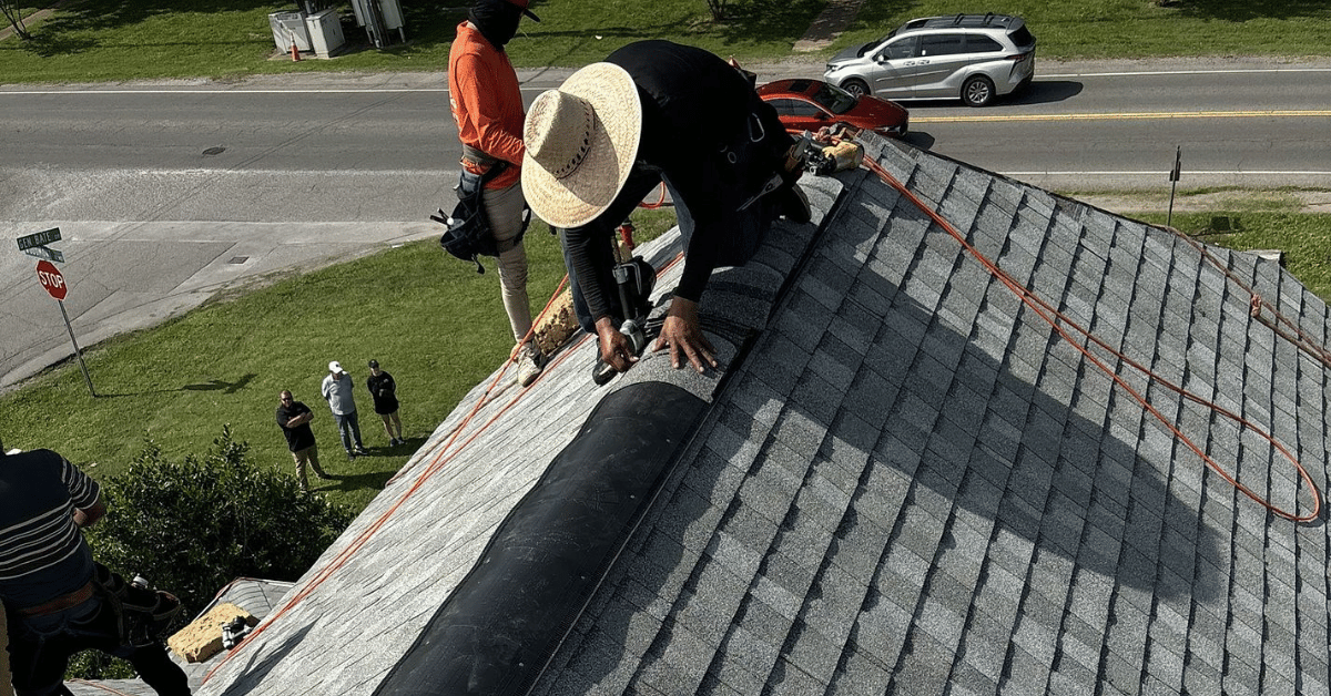 Roofing contractors installing a roof with proper ventilation components.