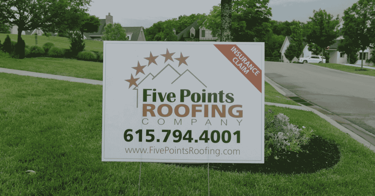A Five Points Roofing yard sign placed on a homeowner's lawn, promoting roofing services and insurance claim assistance.