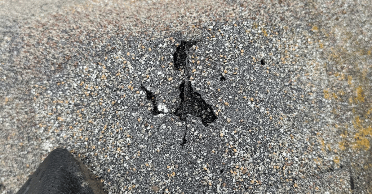 Roof edge with water damage and shingles curling upward, indicating prolonged exposure to moisture.