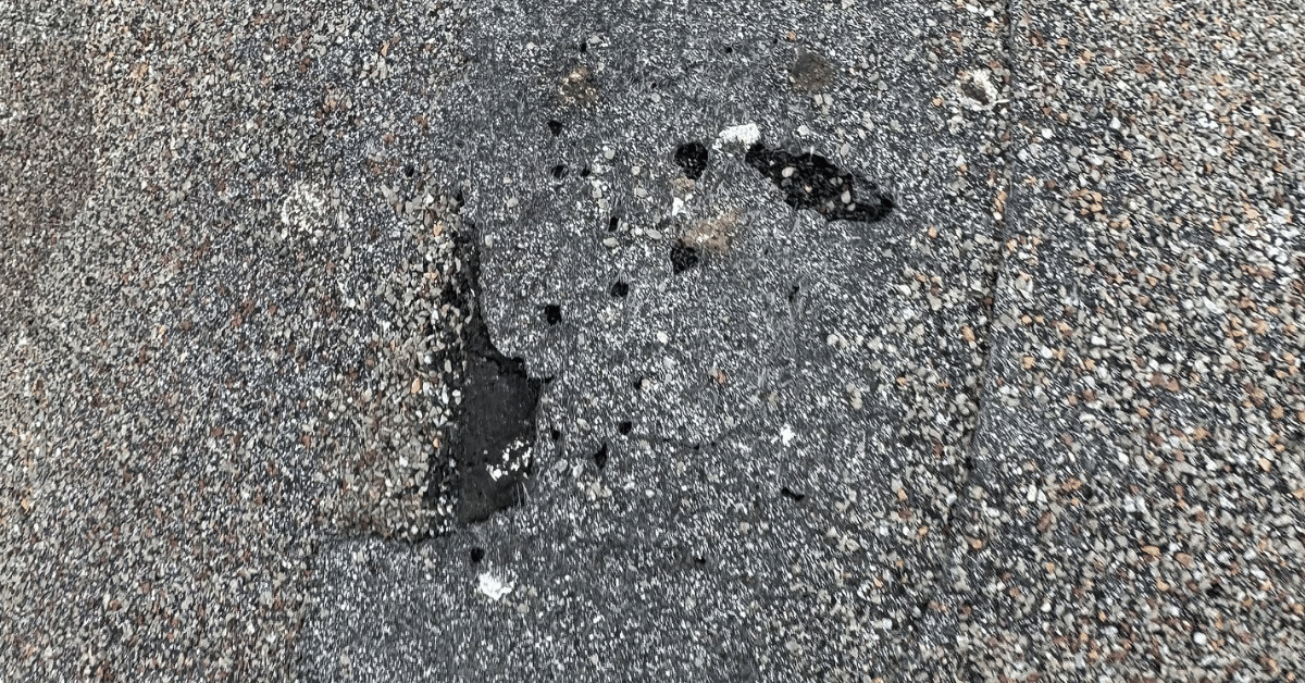 A roof with several missing shingles after a hailstorm