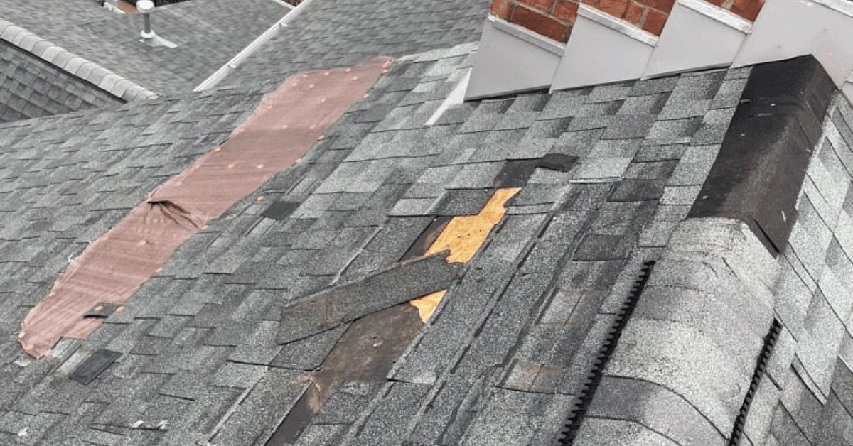 A roof with temporary covers and missing shingles due to hail and storm damage.