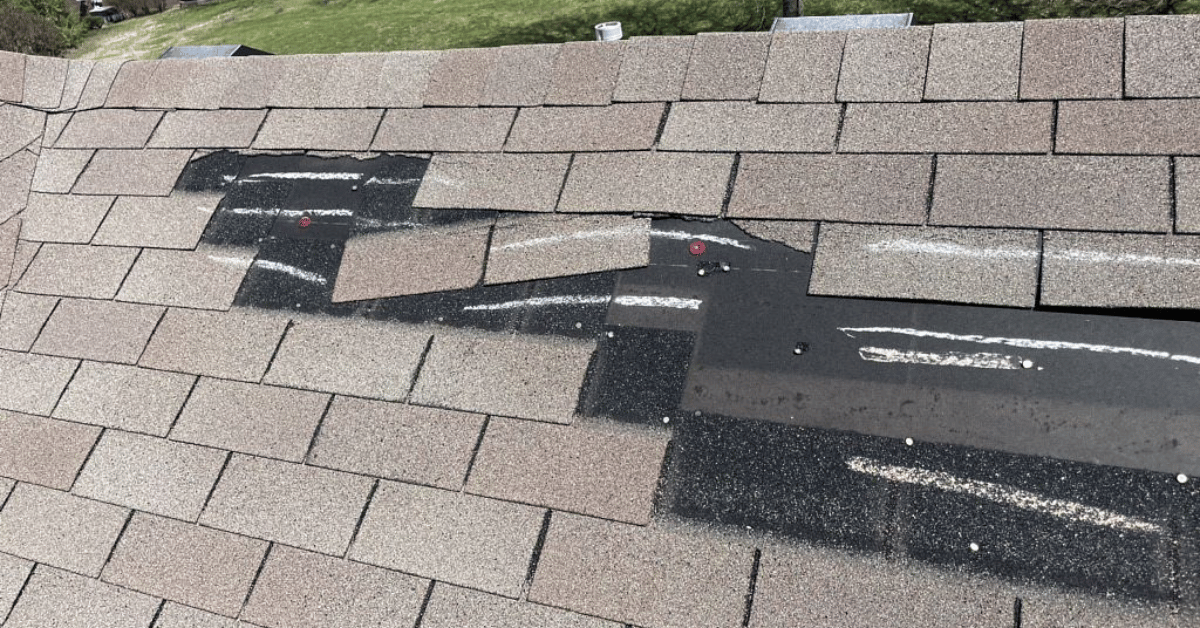 Shingles with chalk markings highlighting hail damage from a recent storm.