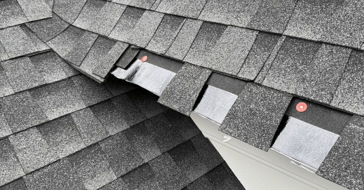 Gutters filled with leaves and debris piling up at roof junctions, causing water drainage issues.