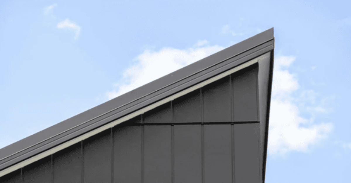 A sleek, modern shed roof with a single slope against a clear blue sky.