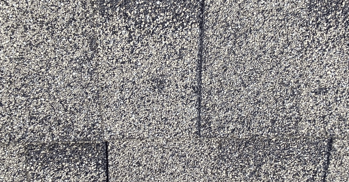 Close-up of cracked and deteriorated Tamko shingles.