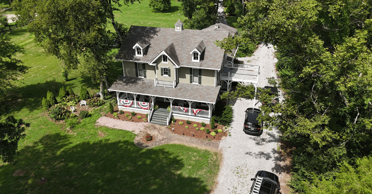 A beautifully maintained home with a newly installed roof, surrounded by lush greenery.