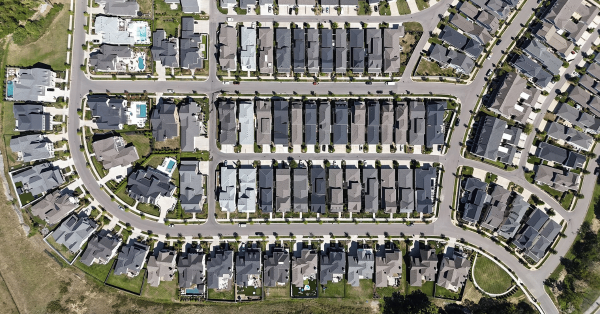 A high-resolution aerial view of a suburban neighborhood with houses closely arranged in neat rows.