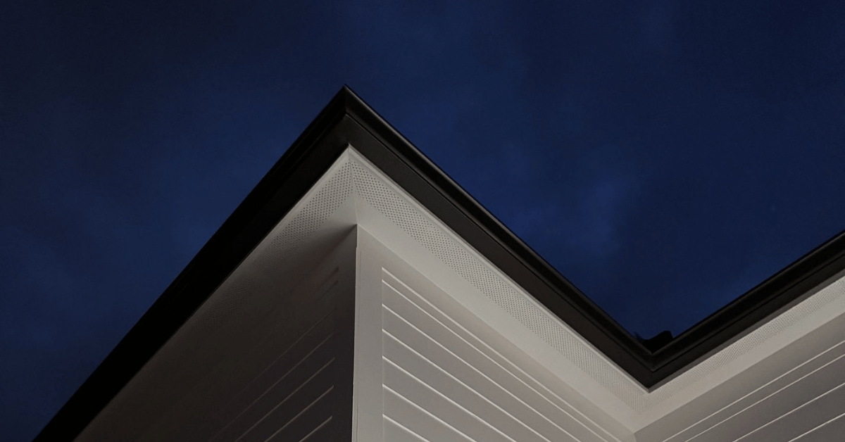 A house soffit and roof edge illuminated at night.