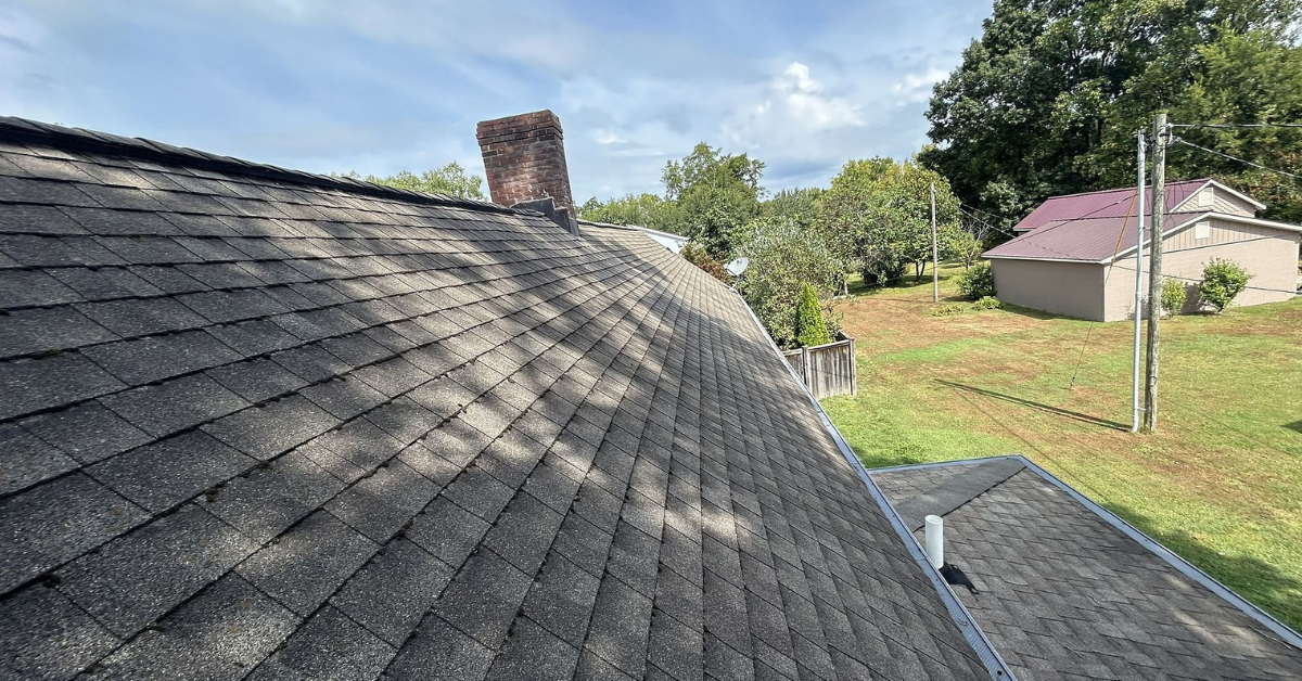 A roof with noticeable sagging along the ridgeline and chimney.