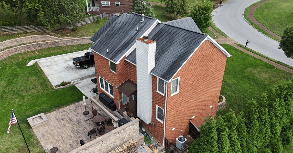 A brick house with a freshly installed and well-maintained roof.