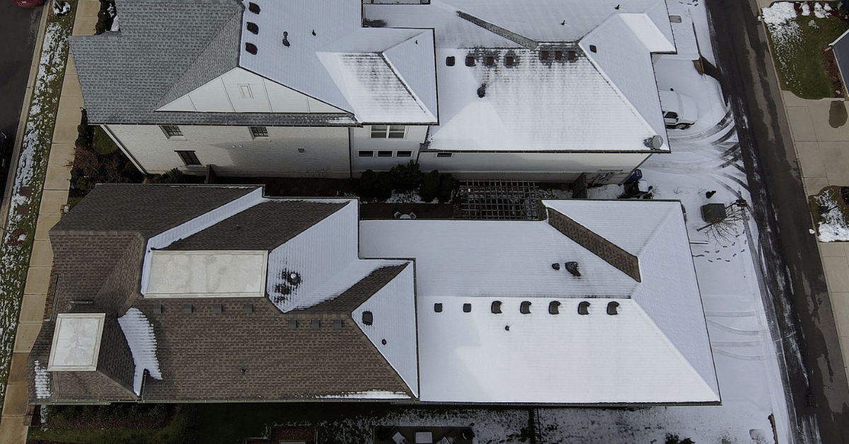 A top-down view of homes with snow-covered roofs, highlighting winter conditions.