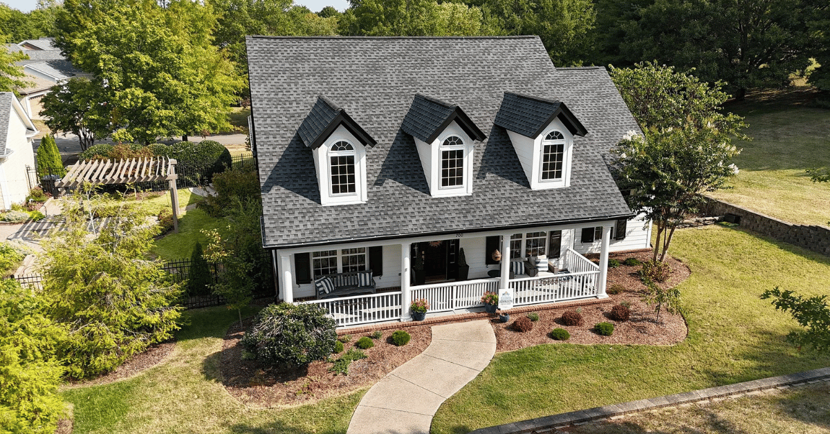 A beautiful home with a well-maintained roof surrounded by green landscaping.