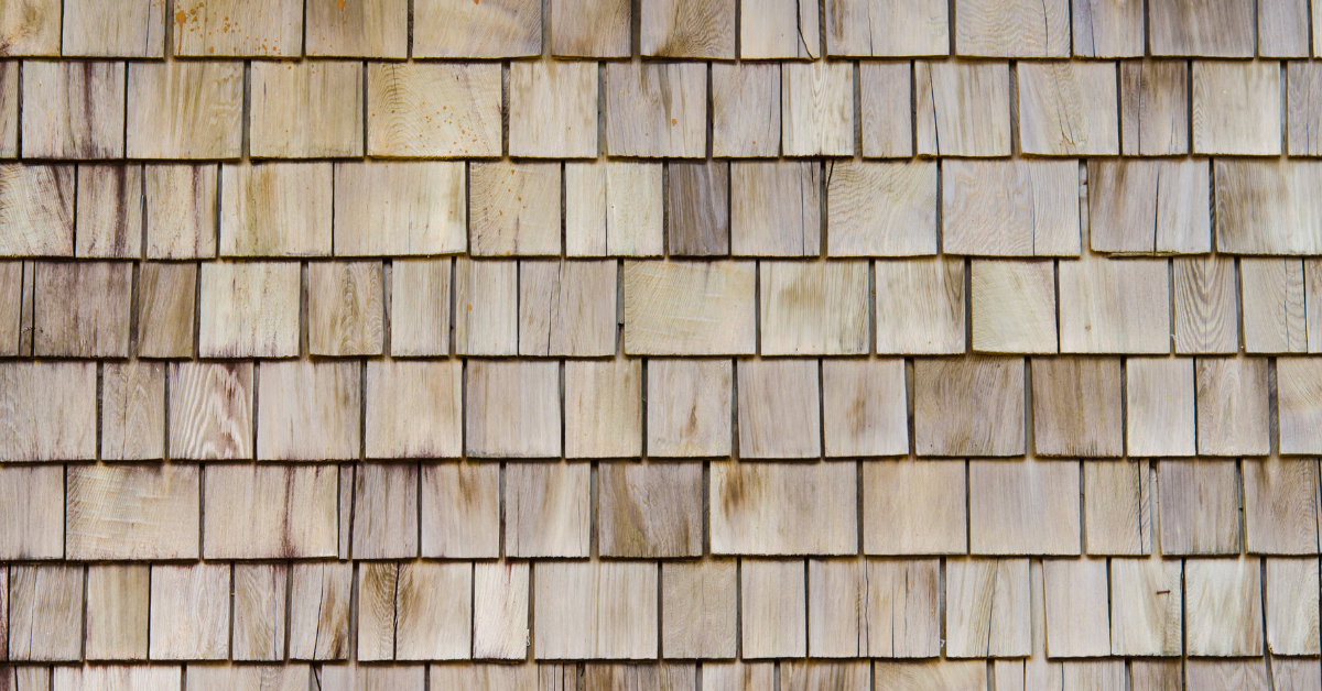 A close-up of natural wood shake shingles with a rustic, textured appearance.