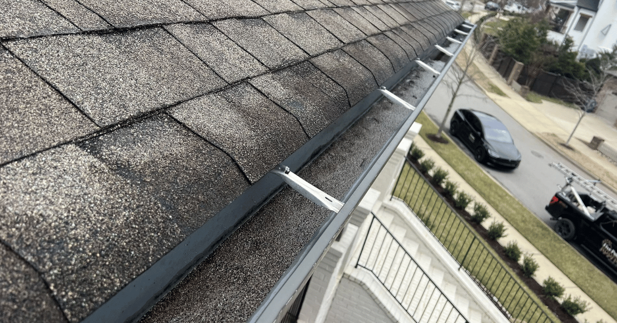 A close-up of a gutter filled with tamko shingle granules, an indicator of potential roof wear.
