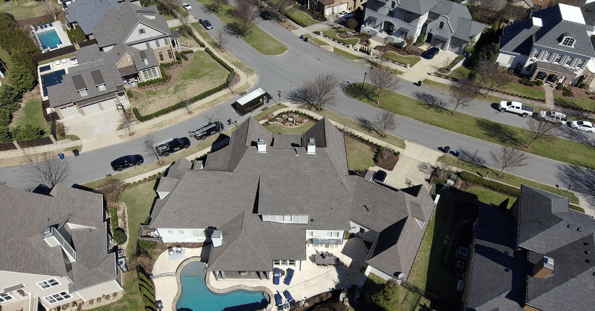 A drone shot capturing a neighborhood with multiple homes featuring TAMKO Heritage shingles.