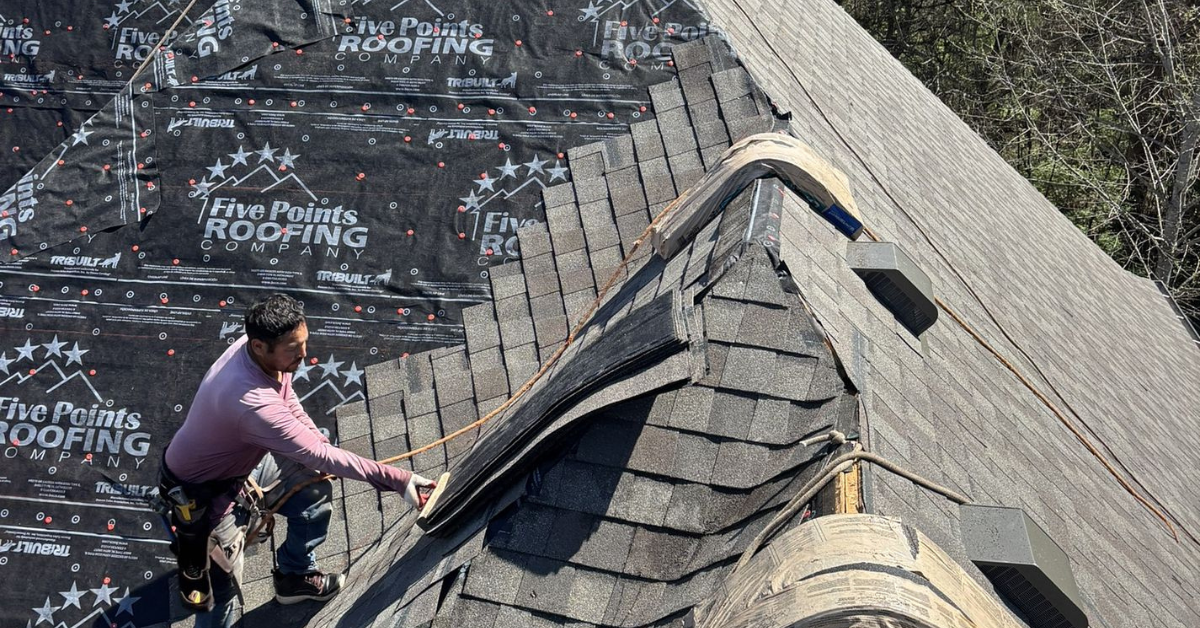 A roofing contractor installing new shingles during a roof replacement project with Five Points Roofing branded underlayment.
