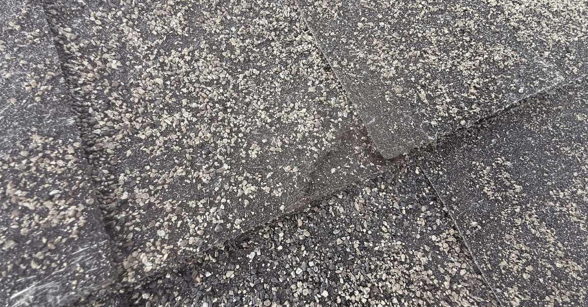 Close-up image of TAMKO shingles with noticeable granule wear, splitting, and cracking.