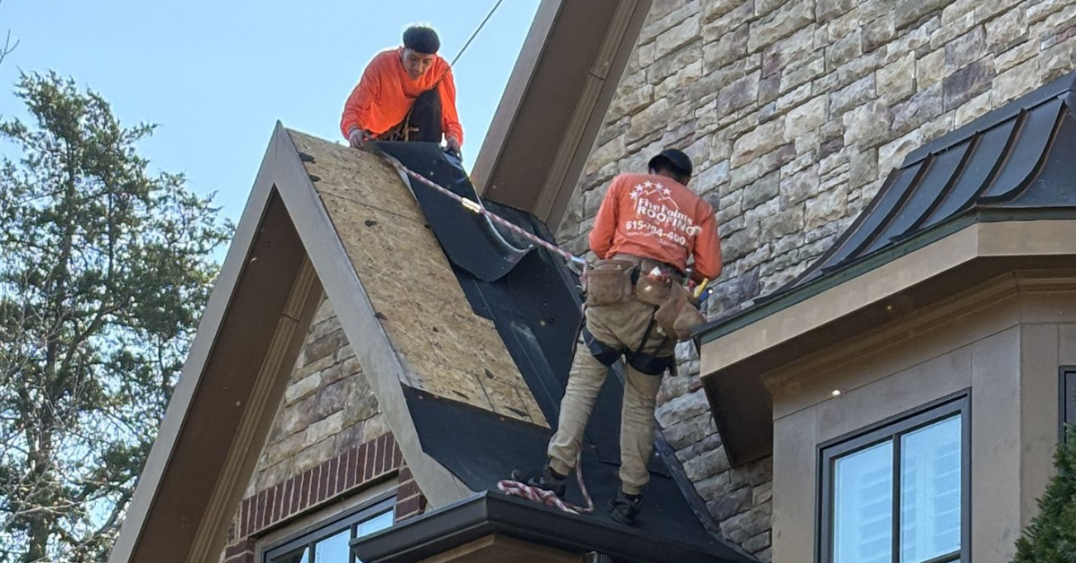Two roofers from Five Points Roofing installing underlayment and preparing the roof for shingle installation.