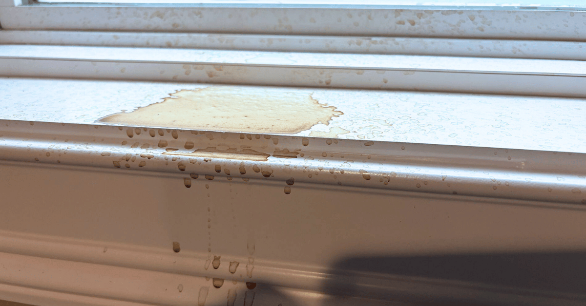 Brown water stains on indoor window frame due to roof leakage