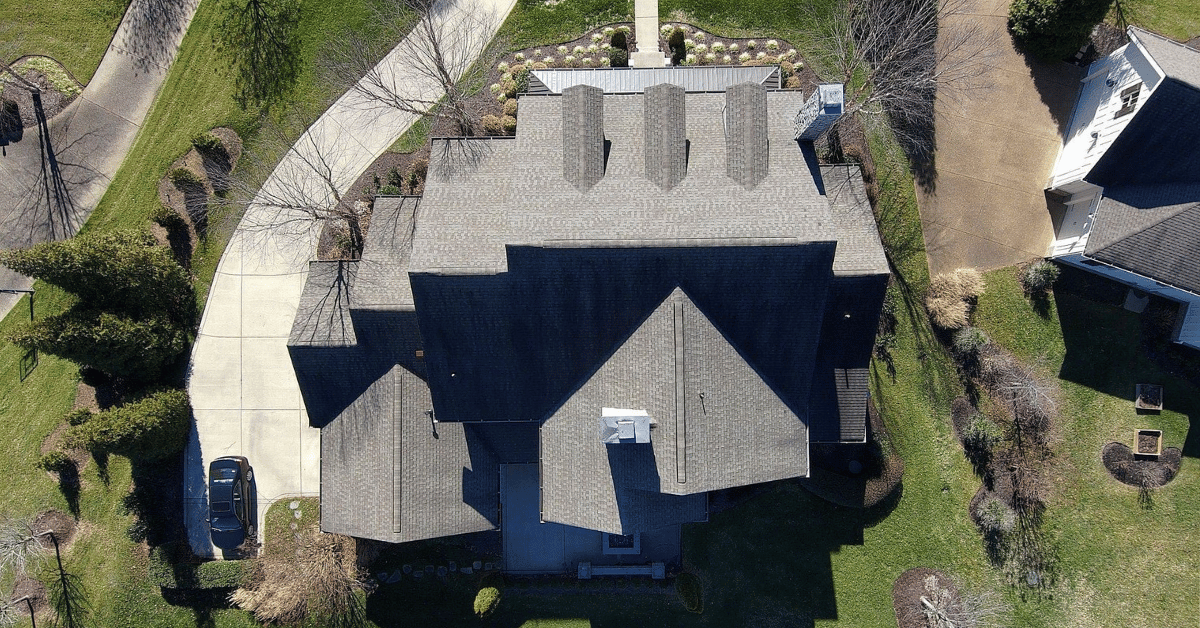 Overhead shot of a large home in Brentwood TN after a professional shingle roof replacement, improving insulation and home energy efficiency.