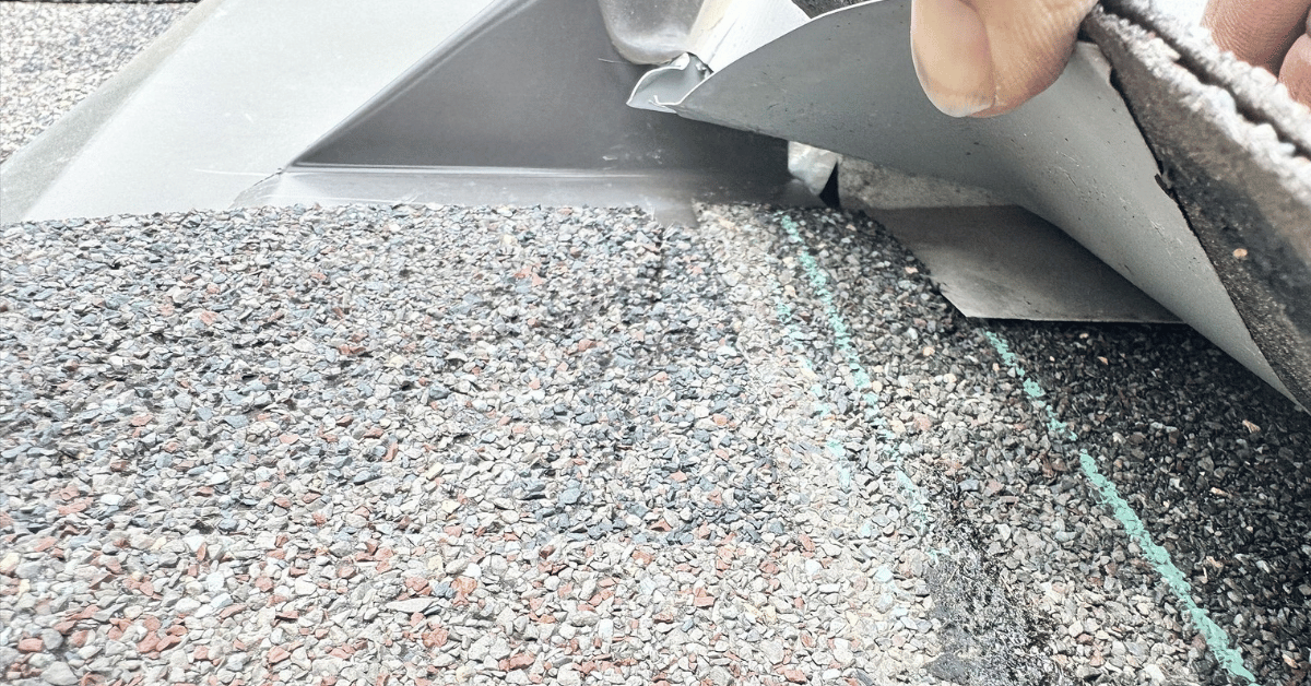 Inspection of exposed fasteners and flashing issues on asphalt shingles, common signs of installation errors that may be covered by warranty.