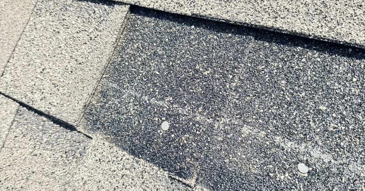 Close-up of improperly sealed shingles with visible nails, a sign of poor installation that can lead to leaks.