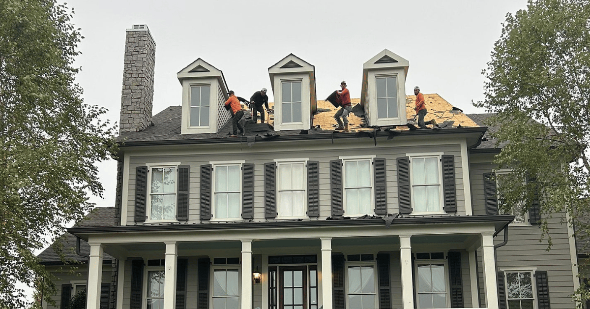 Roofers from Five Points Roofing Company in Franklin TN tearing off old shingles during a roof replacement to prepare for new high-efficiency materials.