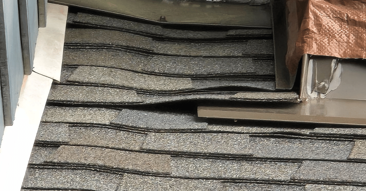 Close-up of a roof layover gone wrong showing lifted shingles, poor flashing, and hidden underlying issues due to re-roofing without tear off.
