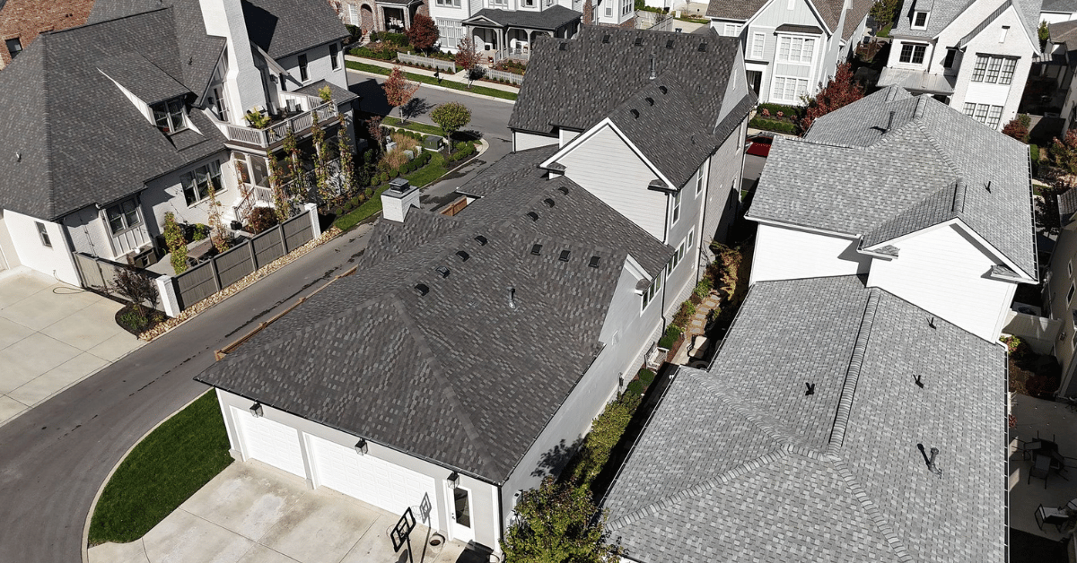 A view of rooftops featuring new roof installations with architectural shingles and proper ventilation, potentially protected by extended roofing warranties.