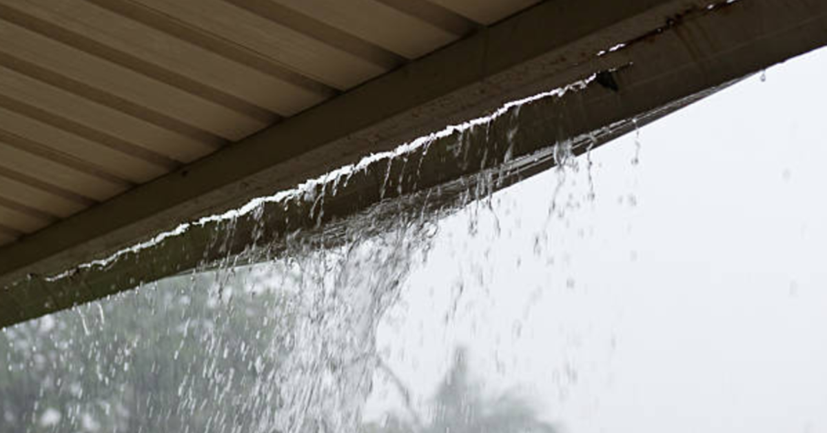 Rainwater overflowing clogged gutter during a downpour a common cause of roof leaks and fascia damage in Nashville homes
