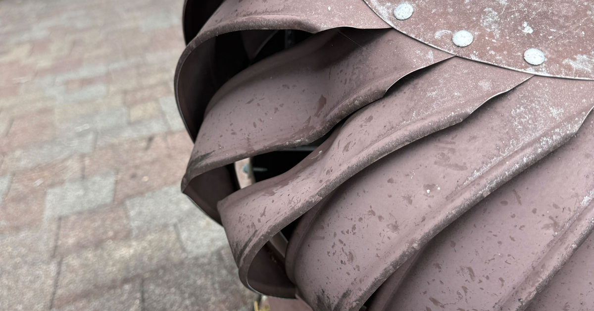 Twisted metal roof vent blades showing clear hail impact damage, compromising ventilation and roof performance.