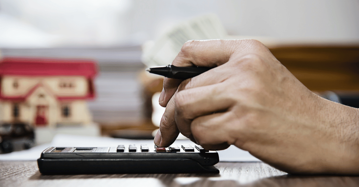 Homeowner using a calculator to estimate deductible, replacement cost value, and out-of-pocket roof claim expenses.