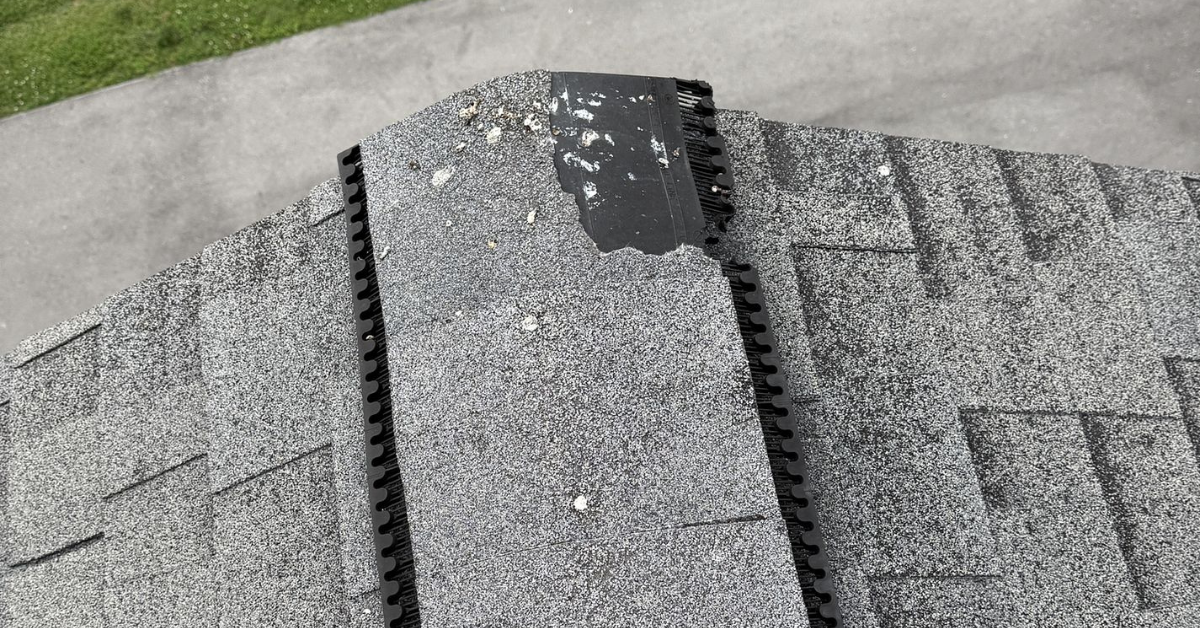 Overhead drone image revealing missing shingles on a steep residential roof, typical after severe hail storms.