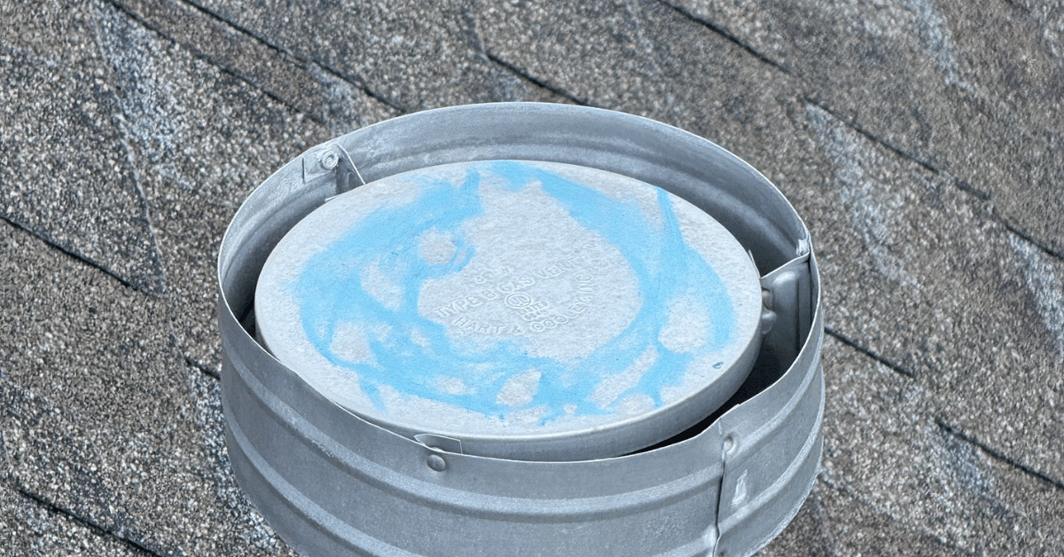 Roof vent with blue chalk markings highlighting potential storm or hail damage for insurance inspection.